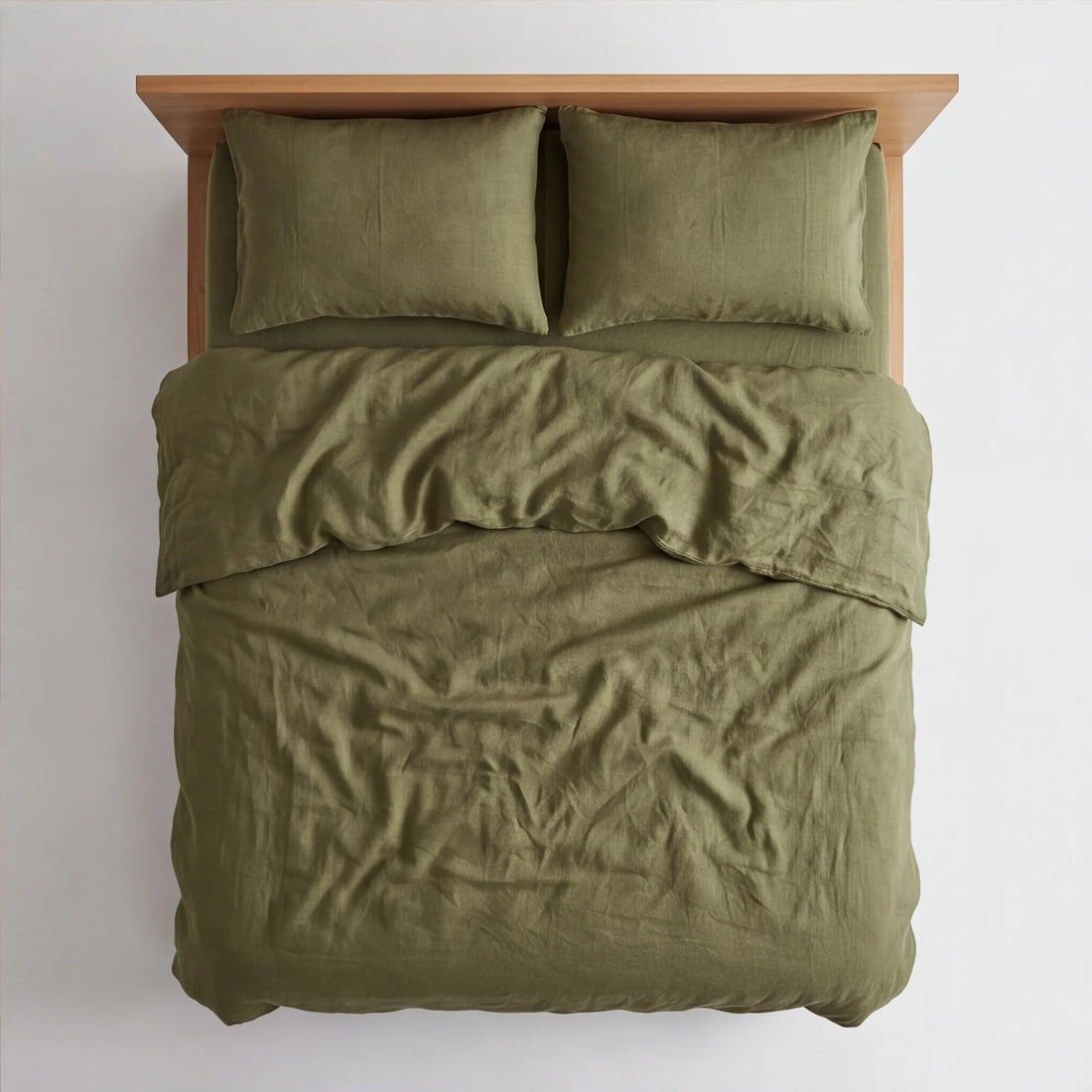 Top-down view of olive green linen bedding on queen platform bed showing full mattress coverage and natural wrinkles