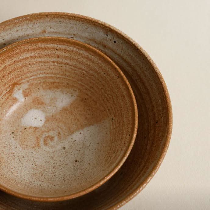 Handmade brown clay tableware set, rustic texture, natural tones.