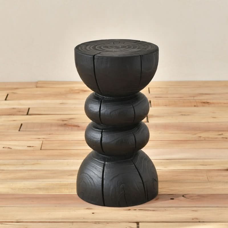 Black Wood Stool with a textured, layered design on a wooden floor.
