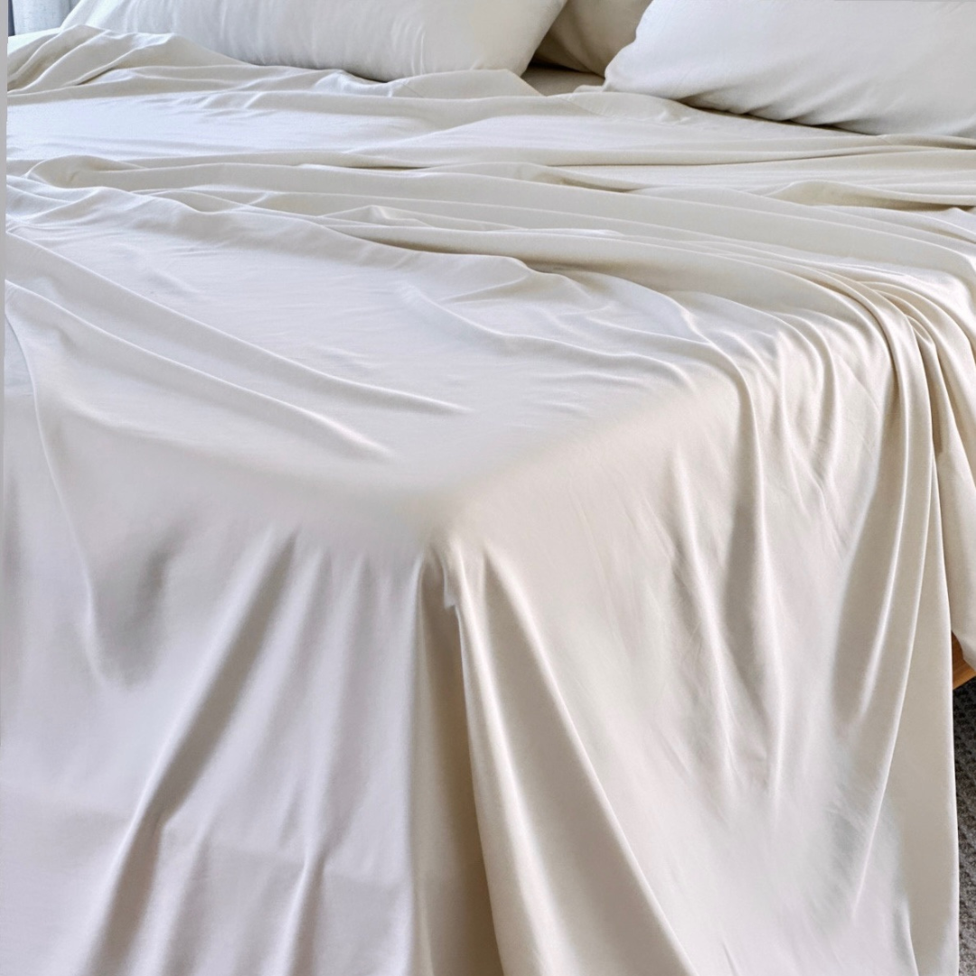 Cream-colored Copper Infused Bamboo Pillowcase Set elegantly draped on a bed.