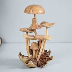 Hand-carved mushroom sculpture made of natural wood, set on a rustic base.