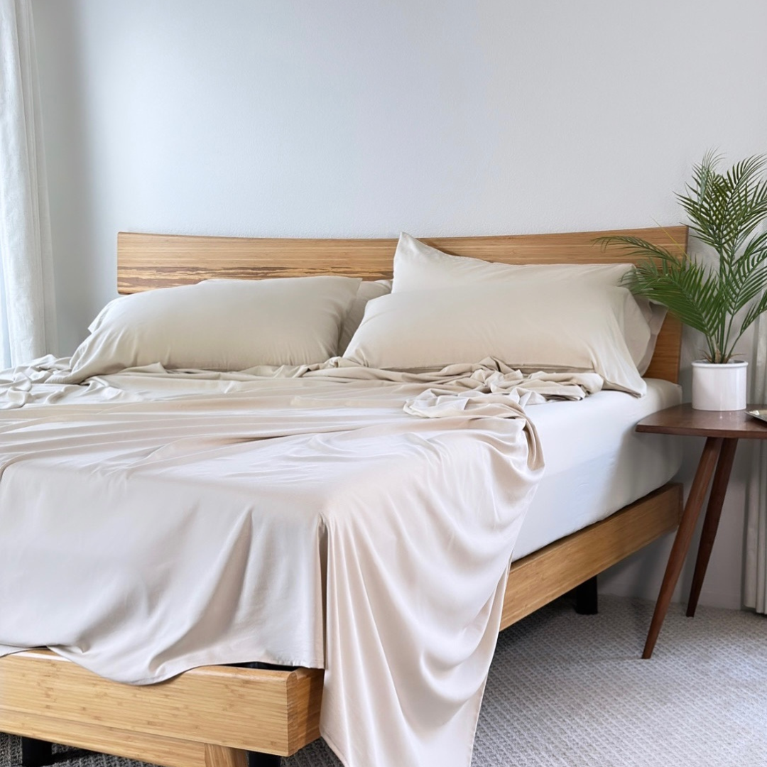 Cream Copper Infused Bamboo Pillowcase Set on a wooden bed frame.