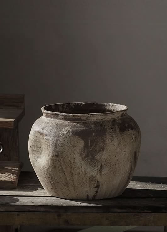 Handmade ceramic vase, rustic beige and brown, home decor on wooden surface.