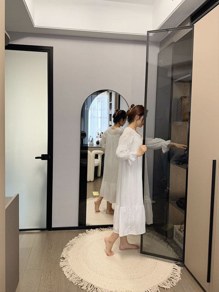 White round wool braided rug with fringe details on a wooden floor.