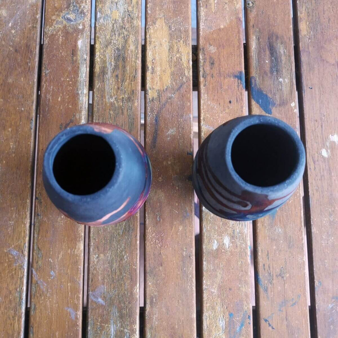 Two dark-colored ceramic vases, unique designs.