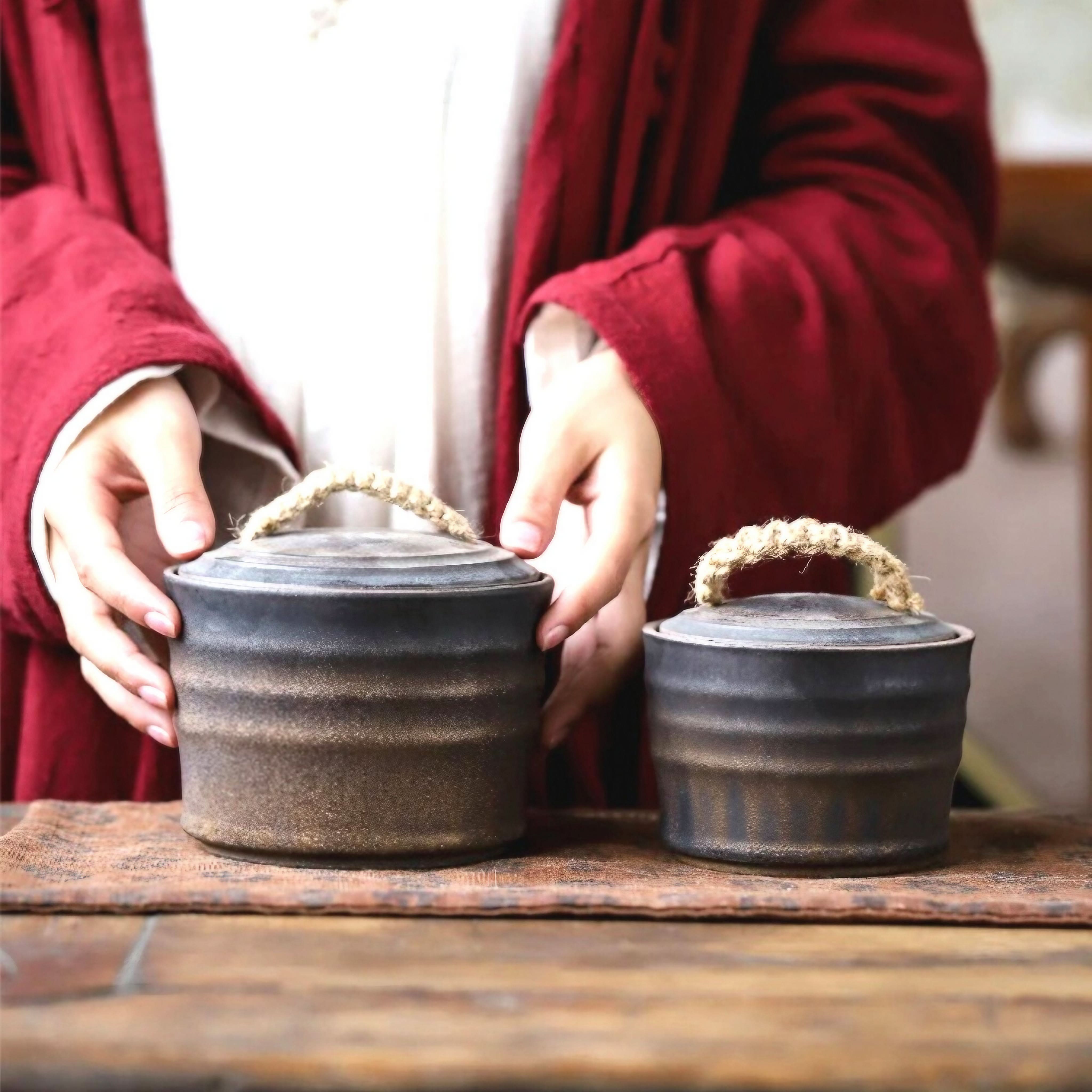 Wabi-Sabi ceramic storage jars with rope handles on a textured mat.
