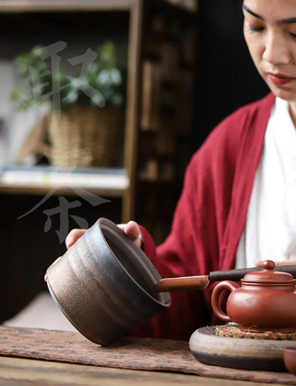 Woman in a red robe using a Wabi-Sabi Bucket Ceramic Jar to store tea