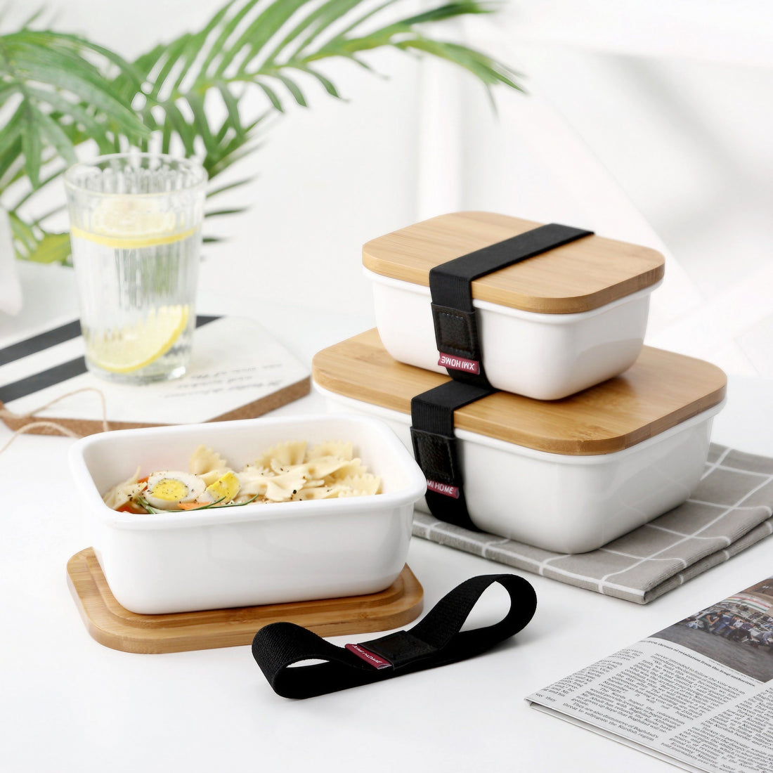 Ceramic bento boxes with wooden lids, showcasing various food compartments