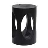 Black wood stool with carved cutout design, a modern home decor accent.