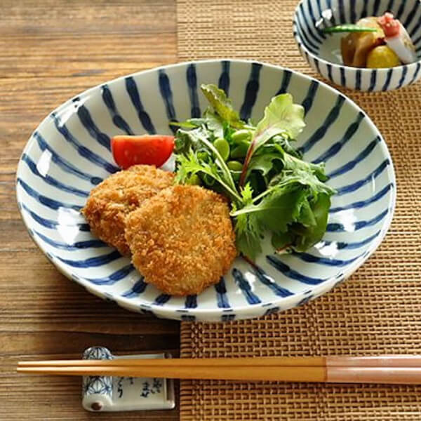 Blue and white striped plate, made in Japan, serving cutlets and salad.