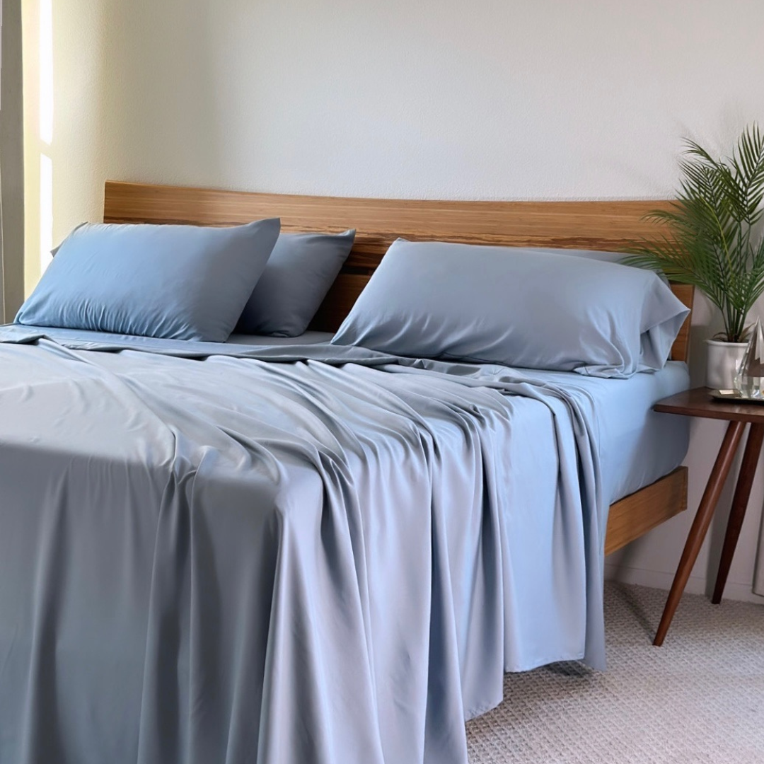Light blue Copper Infused Bamboo Pillowcase set on a bed with wooden headboard.