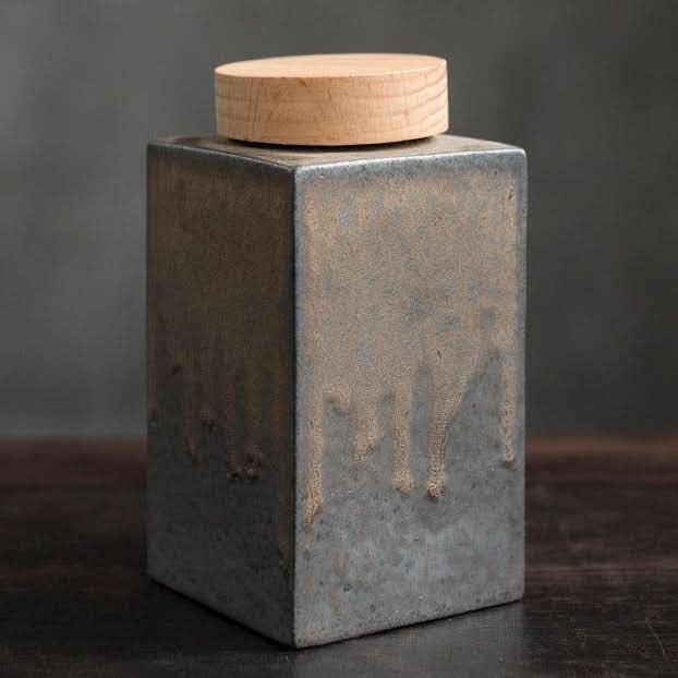 Gray ceramic tea jar with wooden lid, textured finish, home decor.