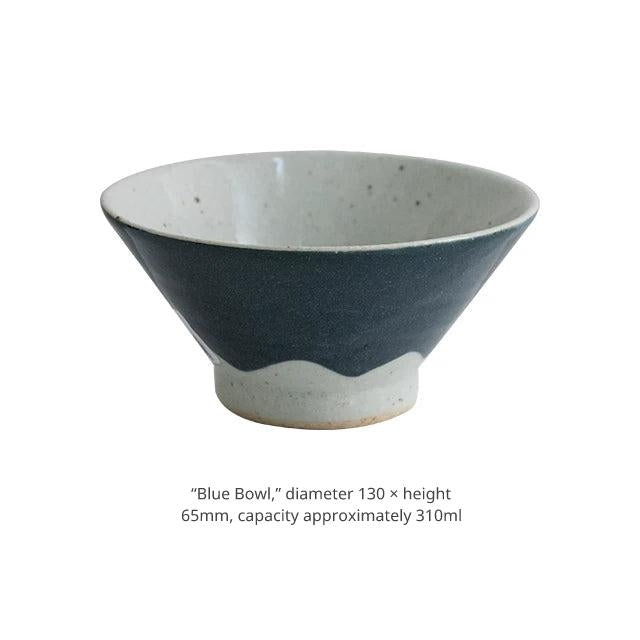 Product shot of a large dark blue ceramic bowl with a wide opening.