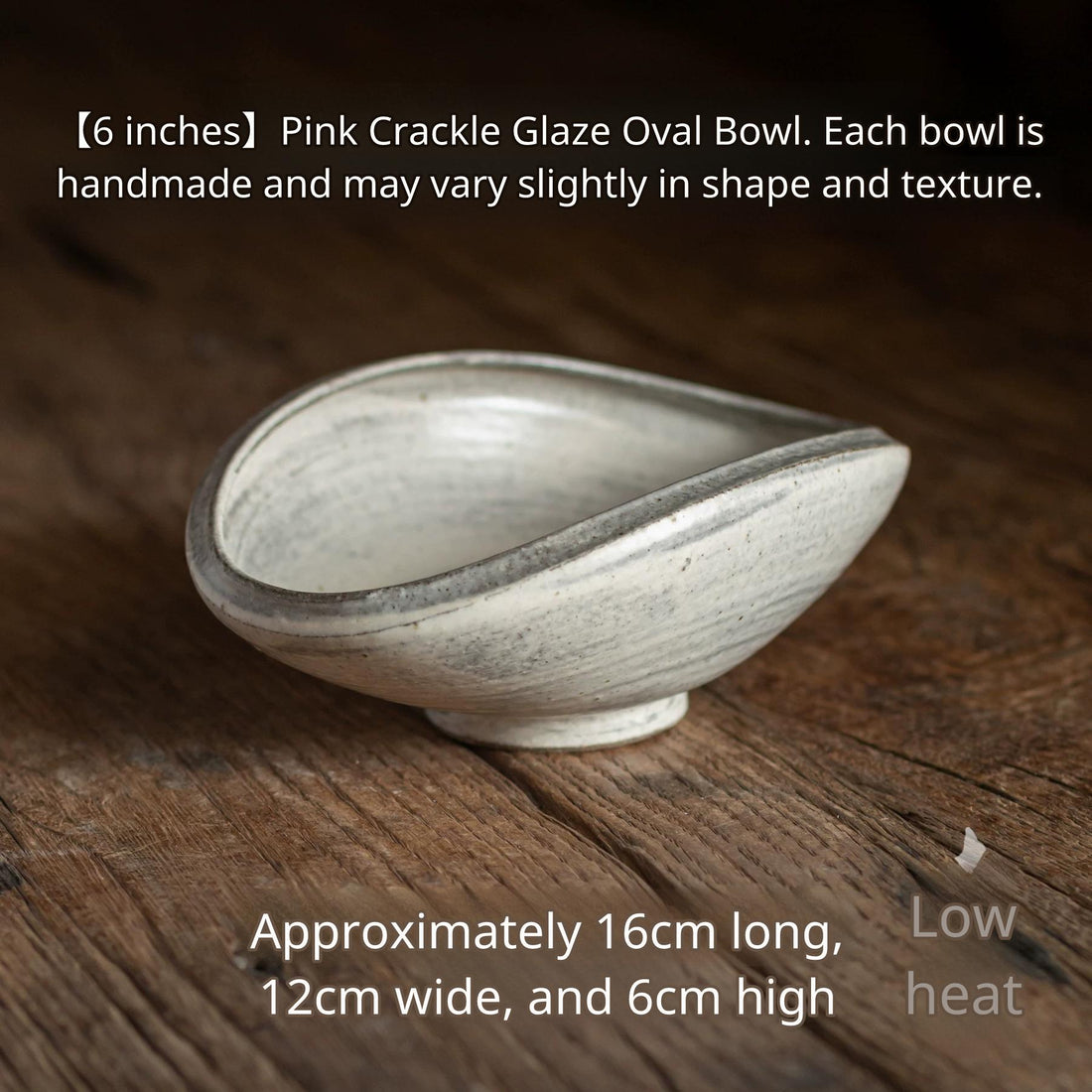 Side view of the 6-inch handmade ceramic bowl with an oblong, flared rim on rustic wood.