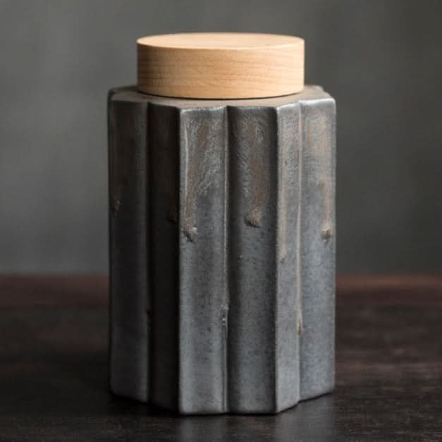 Gray ceramic tea jar with a light wood lid. Modern, textured home decor.