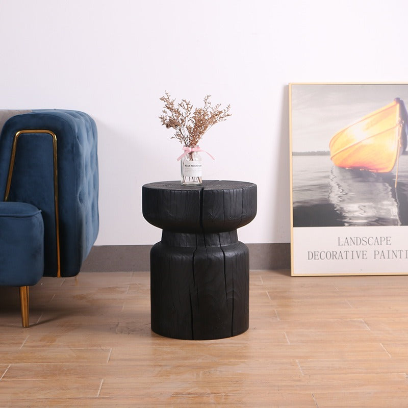 Black wooden stool, rustic design, accent piece.