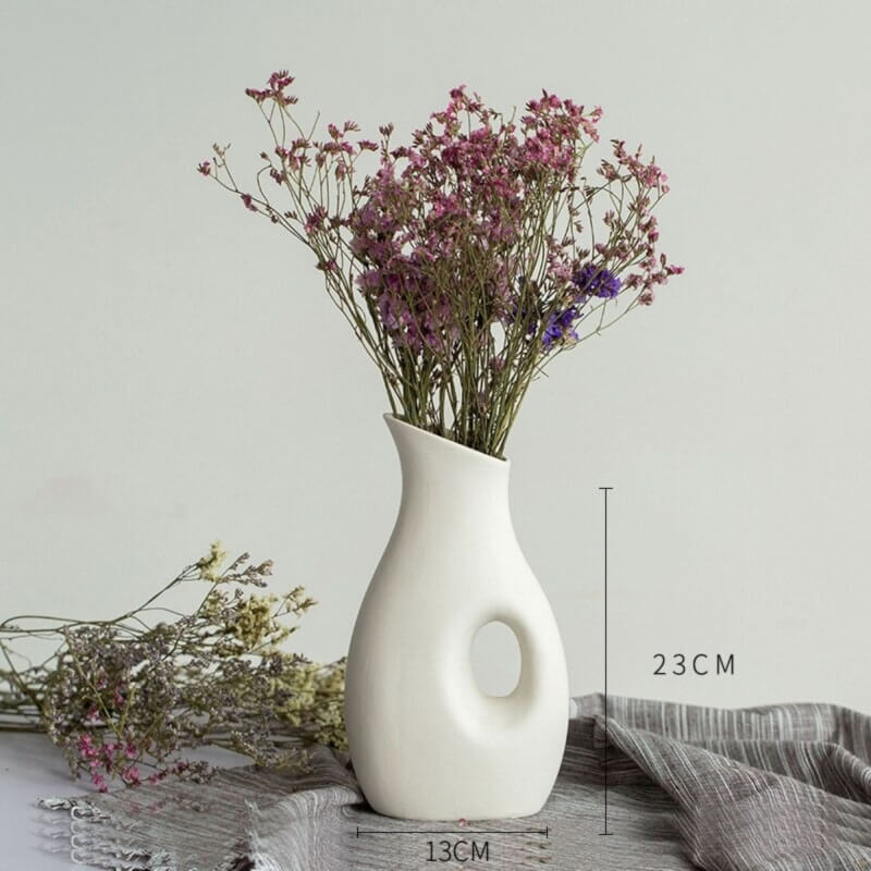 Abstract white vase with dried flowers, minimalist home decor.