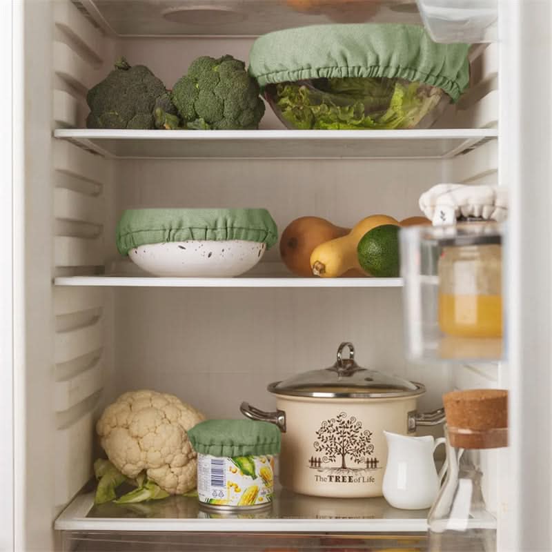 Green linen bowl covers protect food in a refrigerator, keeping produce fresh.