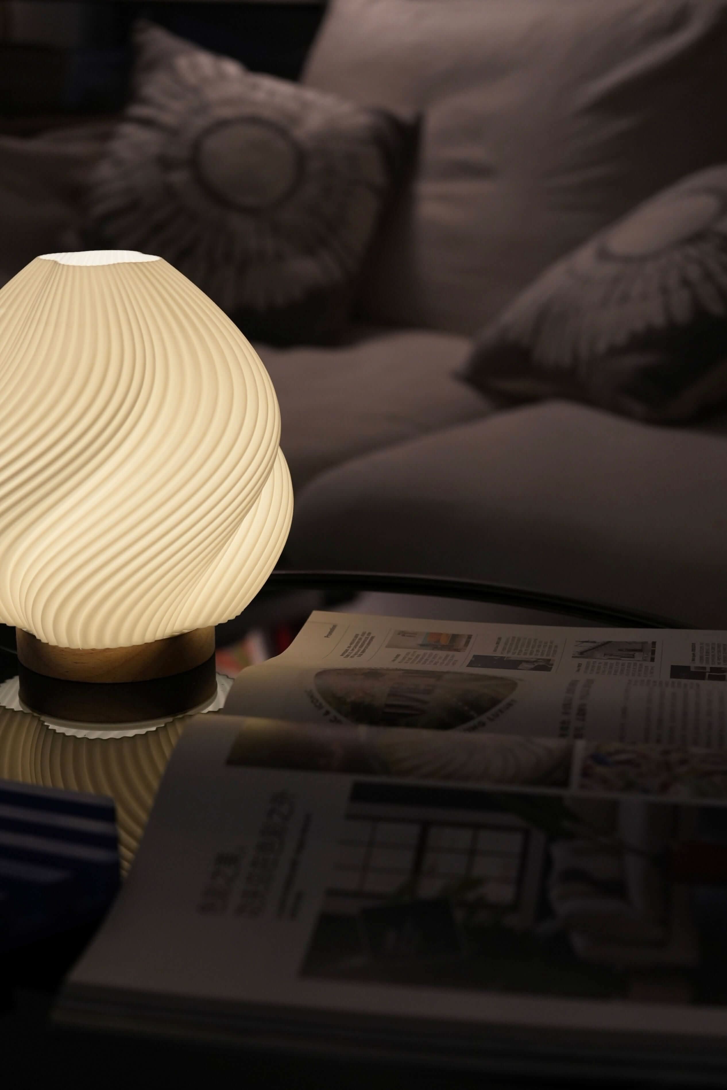 Whimsical Wave Table Lamp: soft ivory ribbed ceramic, wood base, on table w/ magazine