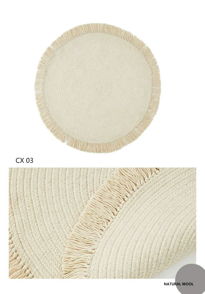 Round wool braided rug in natural cream with fringe detail. Home decor accent.