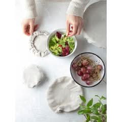 Natural linen bowl covers protecting bowls of salad and grapes.