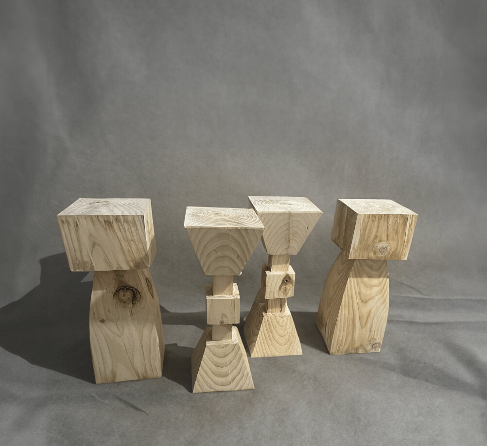 Four solid wood kitchen stools with natural wood grain on a gray background.