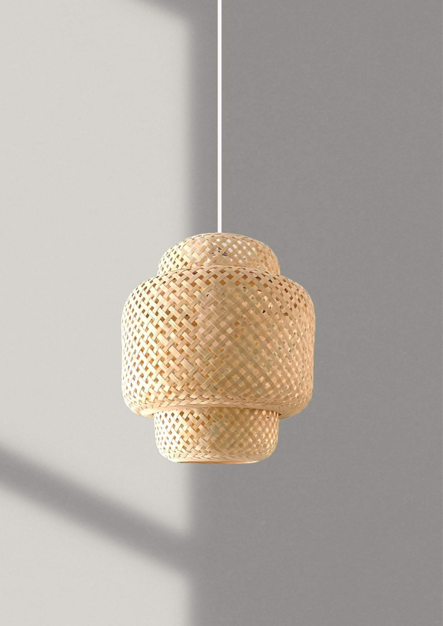 Natural bamboo pendant light with woven texture on a grey background.
