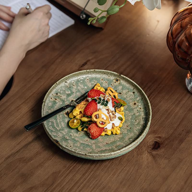 Artisan Green Dinnerware: Speckled ceramic plate with waffle, strawberries, and cream dessert.