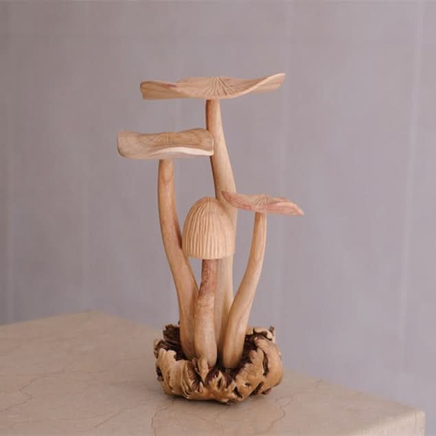 Hand-carved natural wood mushroom sculpture home decor on textured surface.
