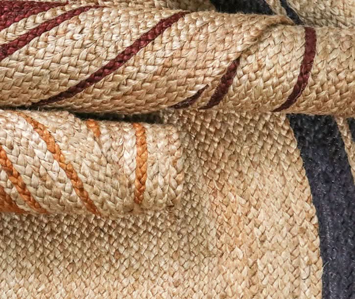 Round Jute Rug with red, orange, and navy stripes. Natural fiber texture.
