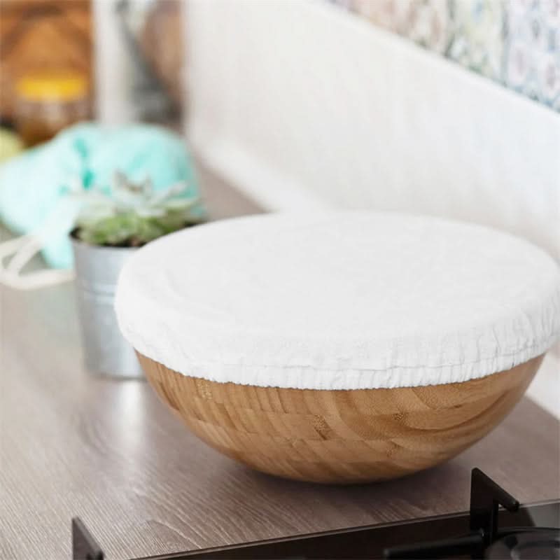 White linen bowl cover on a bamboo bowl, part of a kitchen counter scene.