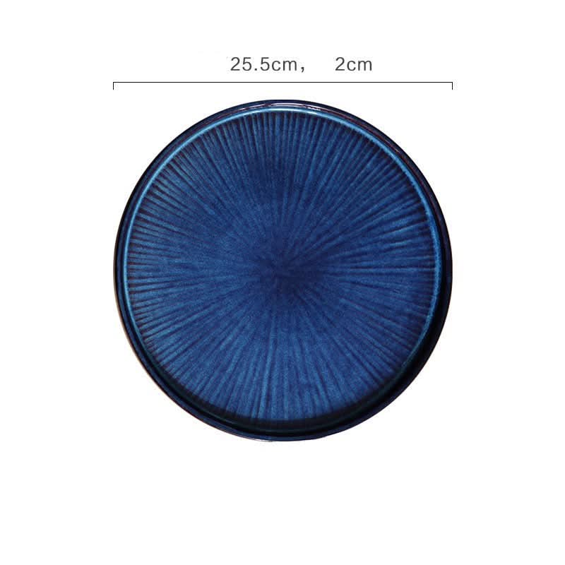 Deep blue flat ceramic glazed plate with radial texture. Kiln glazed tableware.