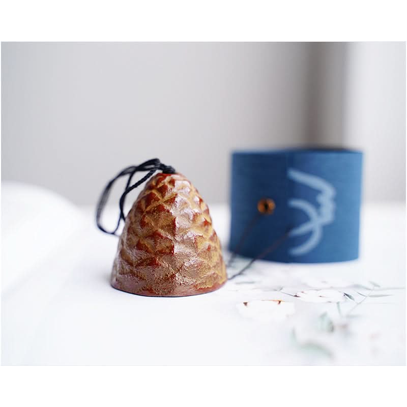 Brown ceramic Japanese Pine Cone Wind Chime with blue patterned holder.