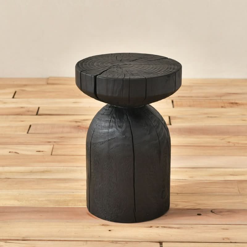 Black wood stool with textured grain on wooden floor