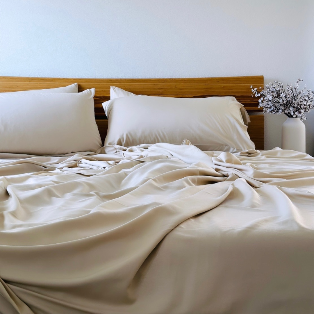 Copper infused bamboo pillowcase set in champagne on a wooden bed.