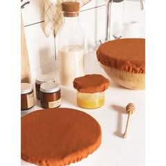 Rust linen bowl covers protecting food in a kitchen setting.
