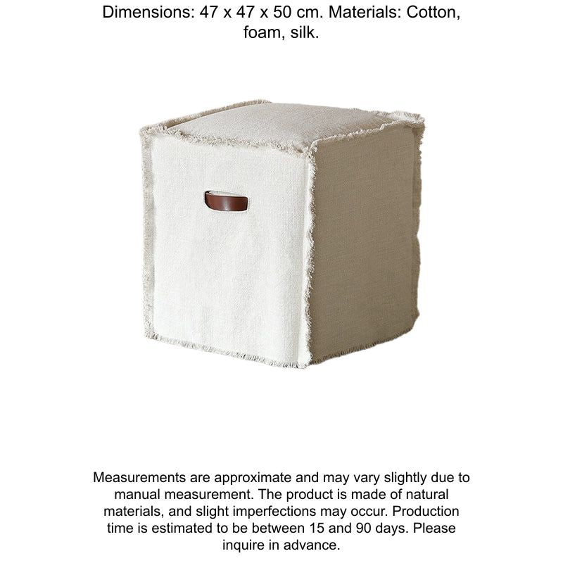 Beige linen square footstool, modern minimalist style.  Square design with frayed edges, light brown leather handle.  Neutral beige color.  On light wood floor.