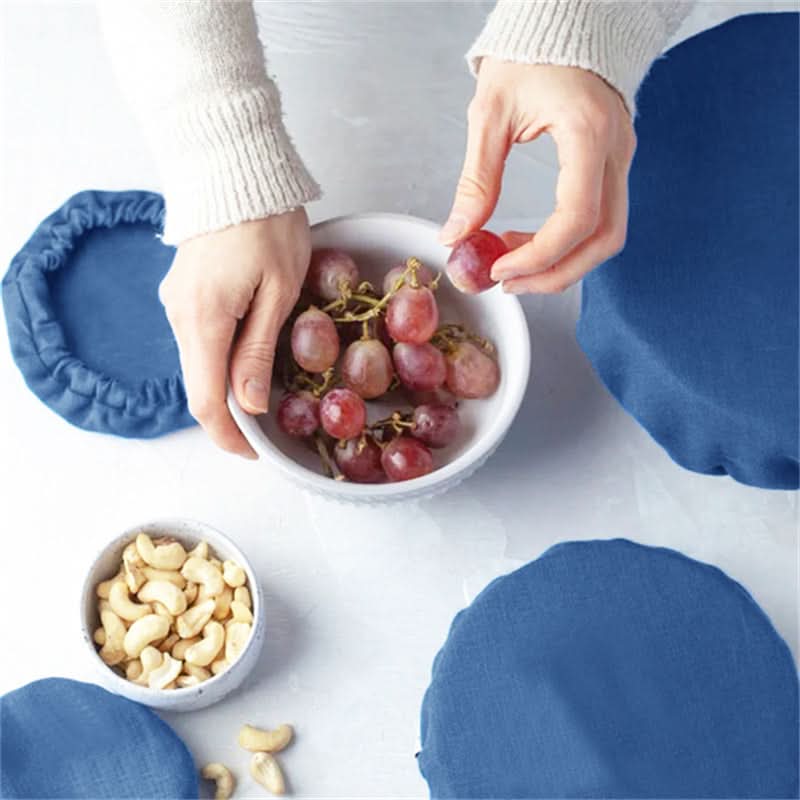 Blue linen bowl covers shown with grapes and cashews, perfect for home decor and food storage.