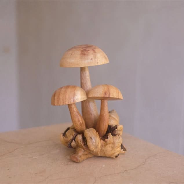 Hand-carved mushroom sculpture on natural wood base, light wood tones.