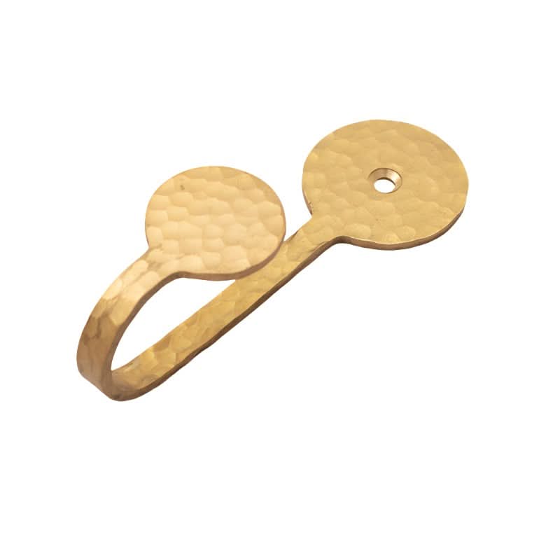 Hammered brass wall hook with textured finish and a hole for mounting.