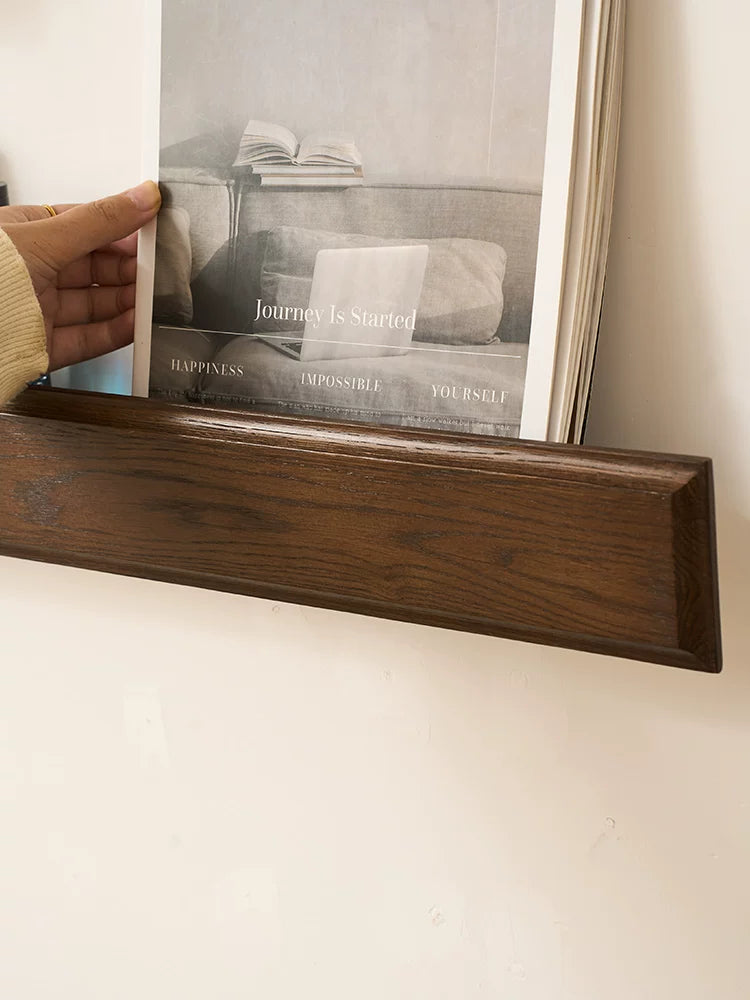 Close-up of dark wood floating shelf edge holding a framed picture with text 'Journey Is Started'.