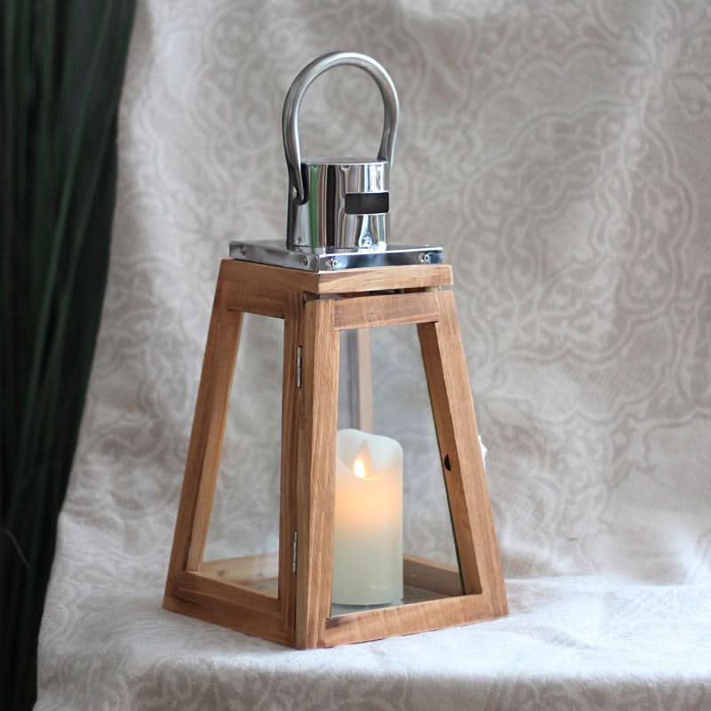 Rustic wooden lantern with metal handle and lit candle, perfect home decor accent.