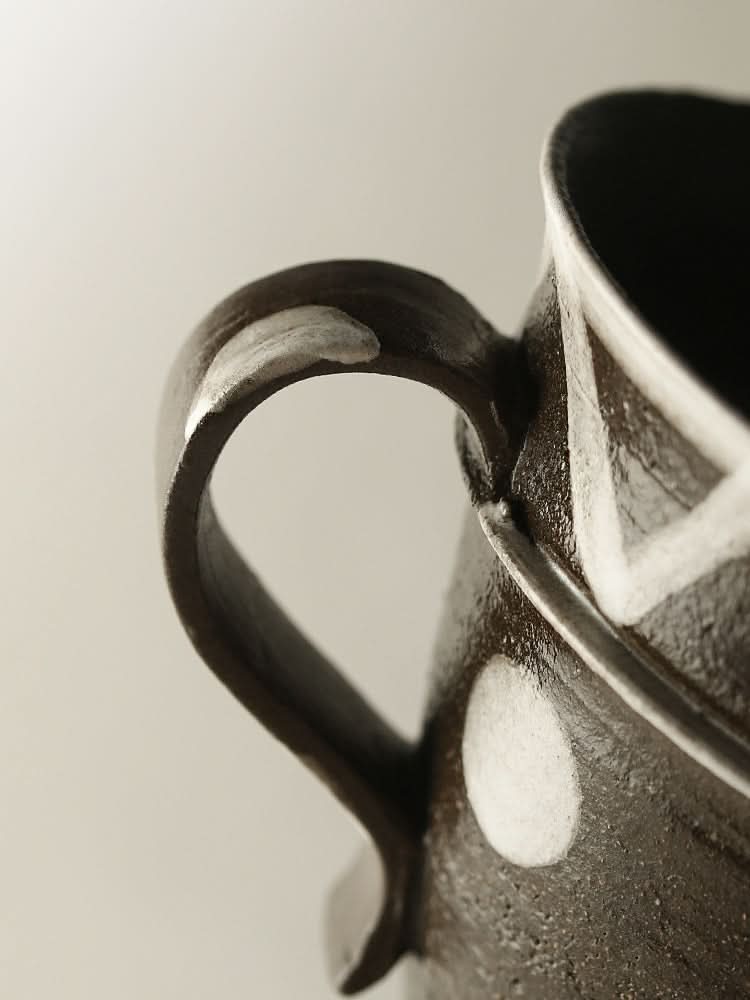 Dark, rustic ceramic coffee cup with white polka dots and geometric design. Unique home decor.