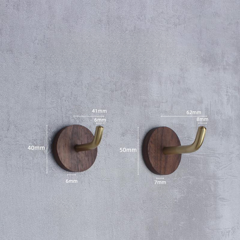 Walnut and brass wall hooks displayed on a textured gray wall with dimensions.