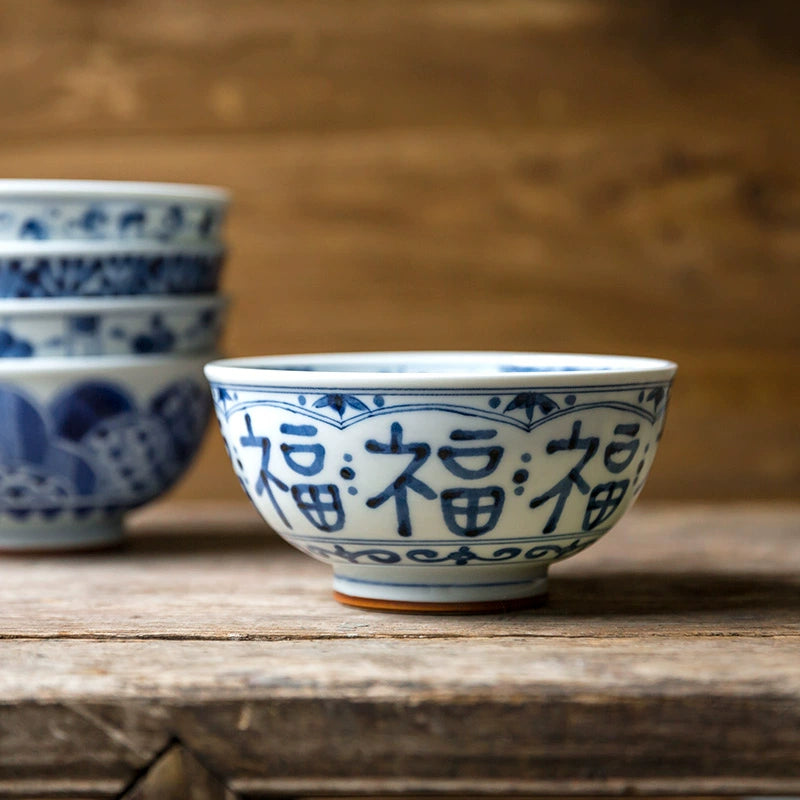 Blue and white floral porcelain bowls set with traditional Chinese design on rustic wood.