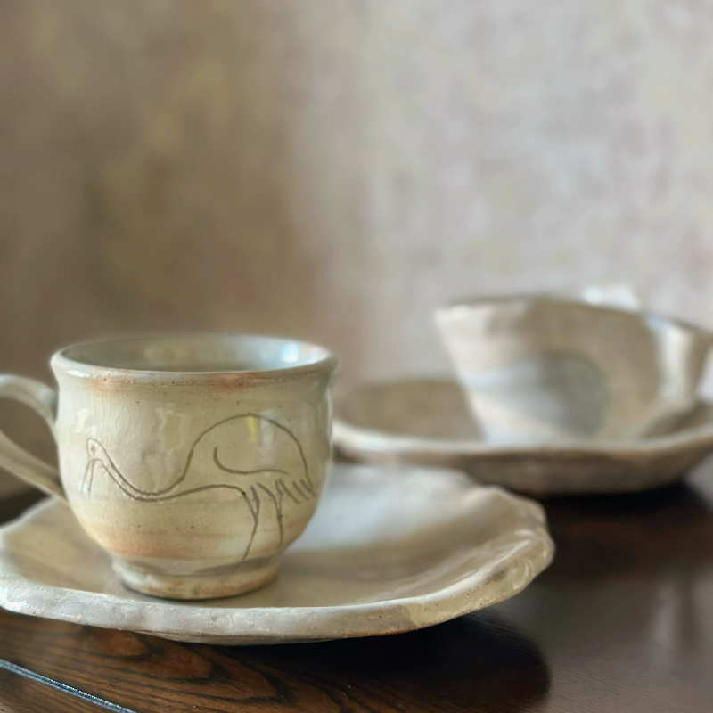Hand-thrown Japanese vintage teacup and saucer set with crane design, natural earth tones.