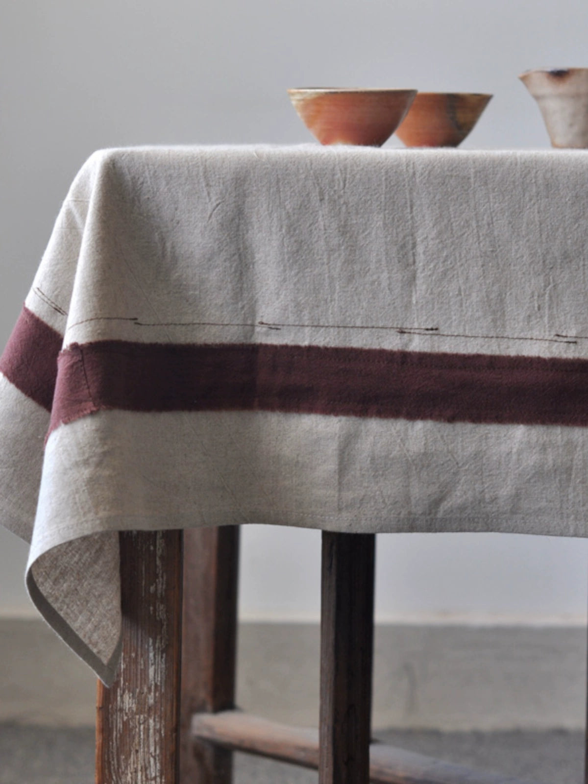 Rustic Linen Tablecloth with Stripes: Natural beige farmhouse style tablecloth with maroon stripes.