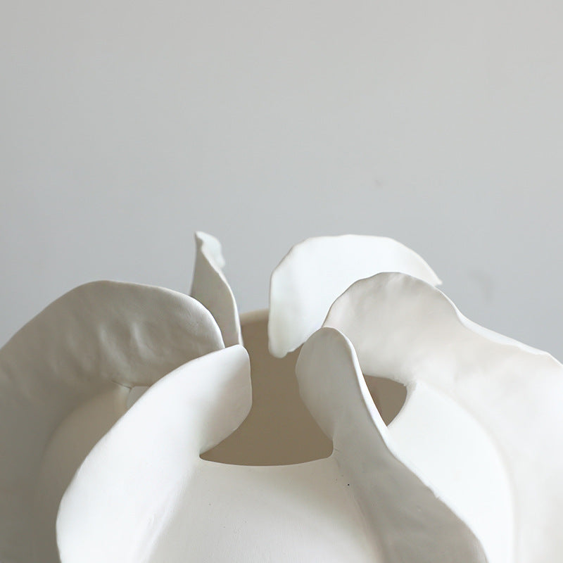 Close-up of a handcrafted white ceramic flower sculpture with delicate petals.