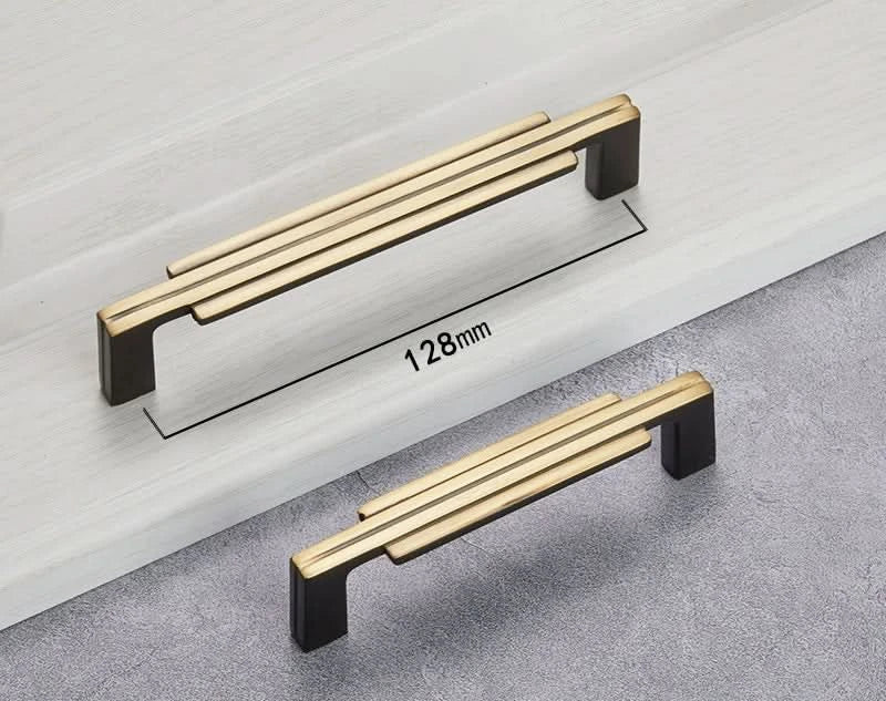 Modern Geometric Cabinet Handles in gold & black copper, on a white surface.
