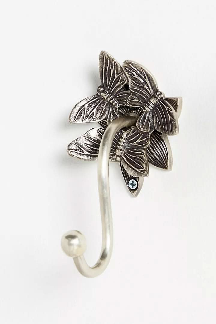 Silver butterfly-design wall hook, part of a bathroom accessories set.